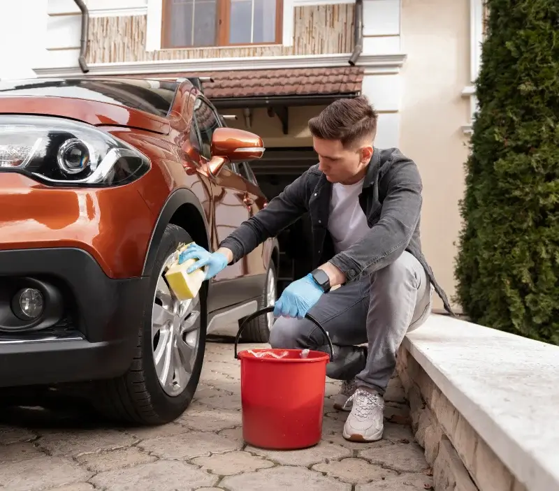 Lavage auto à domicile Manneville-la-Goupil : professionnel intervenant sur un véhicule